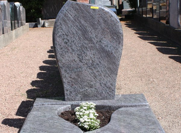 Grabmal aus dunklem Granit mit floraler Gravur