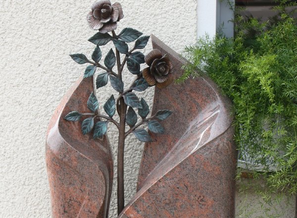 Grabmal aus rotem Granit mit plastischem Rosen-Relief